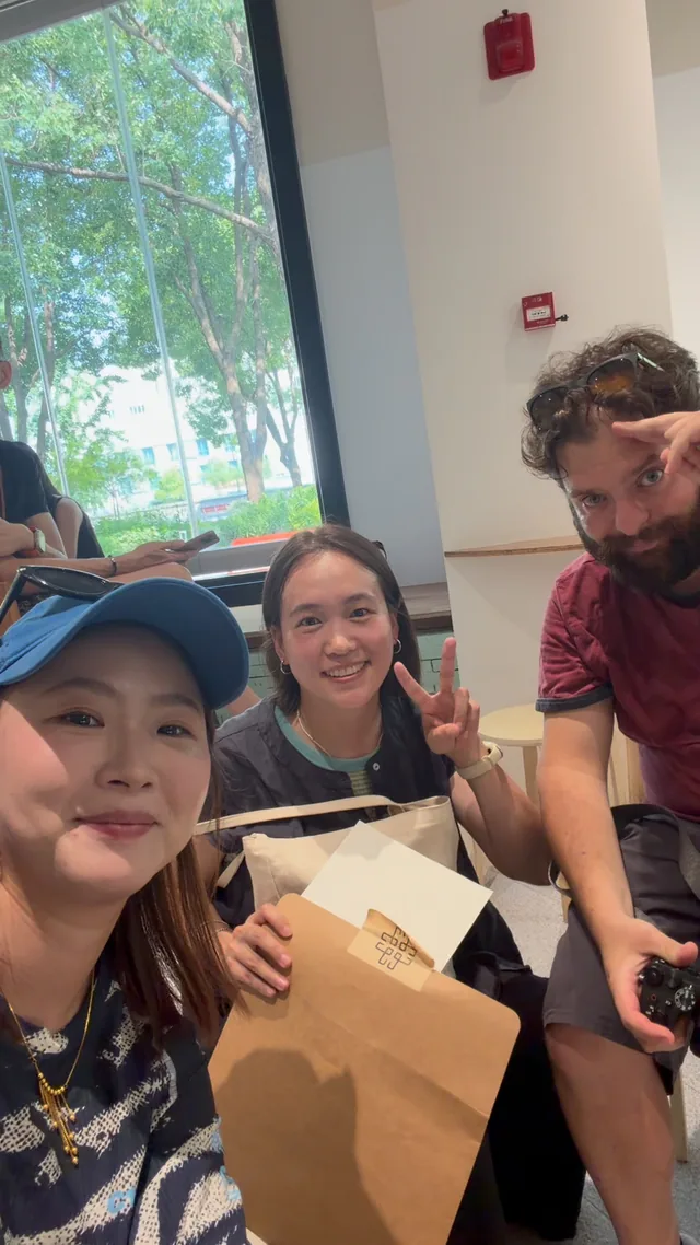 A Buddy and guests taking a three-person selfie indoors.
