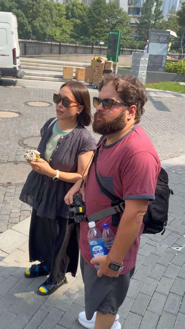 A Buddy and guest pausing together beside a street.