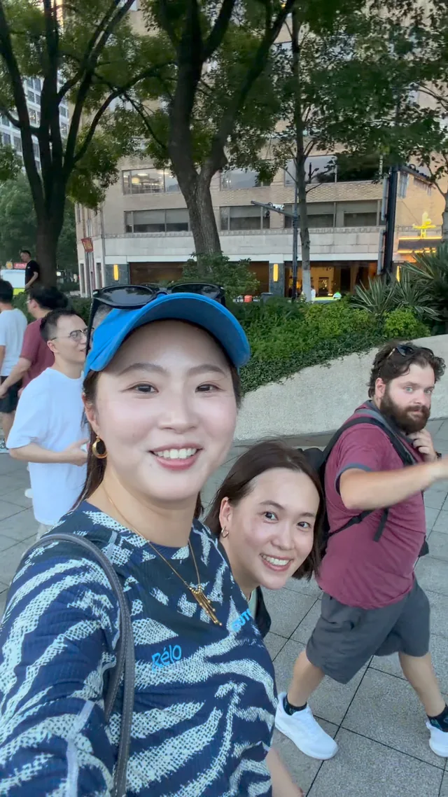 A Buddy and guests taking a three-person selfie outdoors.