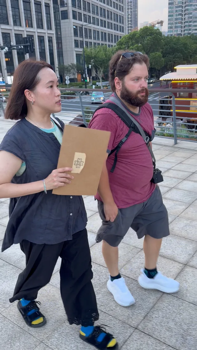 A Buddy and guest walking side by side outdoors.