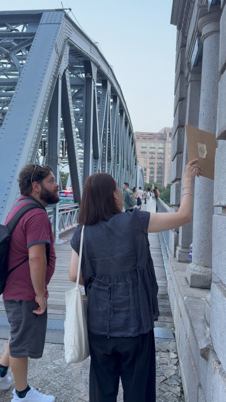A Local Buddy and a guest exploring architectural details beside Waibaidu Bridge.